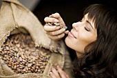 Frau prüft Aroma von frischen Kakaobohnen