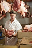 A butcher among cuts of raw meat