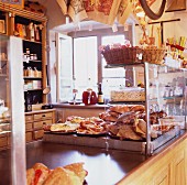 A rustically furnished shop floor with baked goods and other items for sale