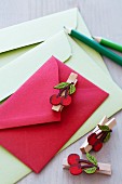 Colourful envelopes decorated with clothes pegs with cherry motifs