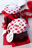 Jars of cherry jam decorated with cherry stickers and bows
