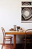 Solid wood dining table with vintage chairs; a black and white poster on the wall