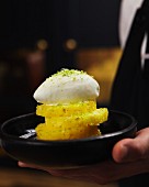 Pineapple slices topped with a dome of whipped cream and lime zest