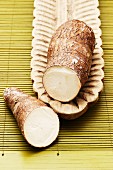 Cassava root, sliced in two, in a wooden dish