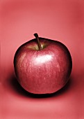 A red apple against a red background