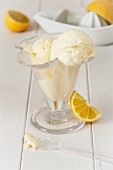lemon ice cream in a glass dish with fresh lemons