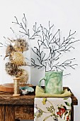 Dried puffer fish under glass cover and ceramic mug on rustic wooden table, stylised coral artwork on wall