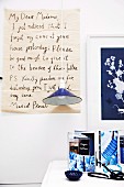 Enlarged, hand-written letter as wall decoration behind blue pendant lamp