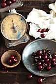 A still life featuring cherries and antique kitchen scales