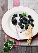 Fresh blackberries and whitecurrants on a plate