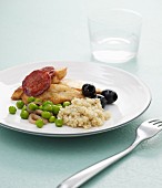 Chicken breast with chorizo, quinoa, olives and peas
