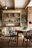 Geschirrschrank und Armlehnstühle im Shakerstil in der Wohnküche einer alten, umgebauten Molkerei in Südafrika