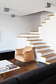 Geländerlose Treppe mit Holzstufen in minimalistisch möbliertem offenem Wohnbereich eines Architektenhauses