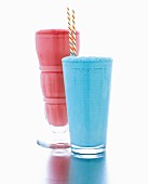 Ein roter & ein blauer Milchshake in Gläsern mit Strohhalm