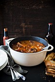 A hearty bean soup with lamb shank in a casserole pot