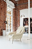 Retro armchair and classic arc lamp by Achille Castiglioni in purist, empty loft interior with brick walls and white-painted floor