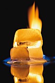 A burning ice-cube against a black background