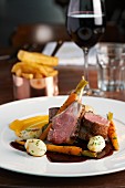 Roast lamb with carrots, chips, a glass of red wine