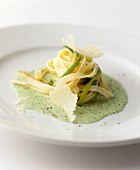Colourful pasta ribbons on a herb foam