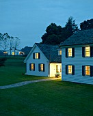 Woman on chair in front of house at dusk