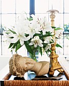 Interior Stillleben mit Büste und weiße Lilien neben goldenem Kerzenständer auf Tablett