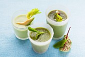 Three green smoothies in juice glasses