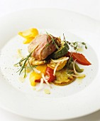 Pork fillet wrapped in ham on Mediterranean vegetables