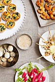 Assorted party snacks (mini spinach quiche, prawn and satay skewers, quail's eggs, radishes)
