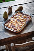 Pear clafoutis in the baking dish on a wooden table