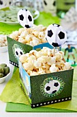 Paper boxes with football motifs being used as popcorn buckets