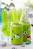 Soda cans being used as cutlery holders with football decorations