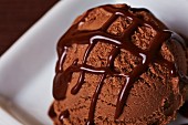 A scoop of home-made chocolate ice cream with chocolate sauce