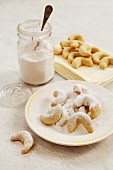 Vanillekipferl (crescent-shaped vanilla biscuits) being topped with vanilla sugar