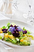 Salad leaves with oranges and edible flowers