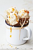 Three ice cream cones with apricot ice cream in an enamel mug