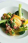 Fried halibut fillet with bacon, broccoli, peas and potatoes