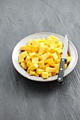 Diced squash on a plate with a knife