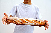 A boy holding a baguette