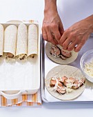 Tortillas being filled and rolled