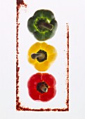 Three peppers, backlit, with a frame made from ground paprika