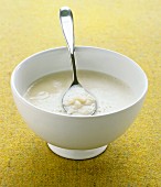 Cauliflower soup in a bowl with a spoon