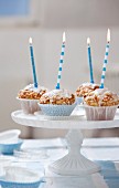 Four muffins with birthday candles