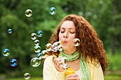 Woman blowing soap bubbles into the air