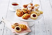 Assorted cakes, biscuits and pastries served with tea, on a cake stand and on napkins