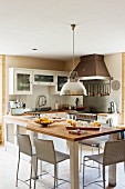 Kitchen-dining room with glass cupboard doors, counter-height table and industrial-style pendant lamp