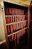 Lots of sausages in a smoking chamber