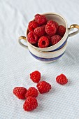 Raspberries in a cup and to one side