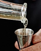 Mezcal being poured into a Jigger