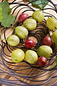 Red and green gooseberries in a wire bowl