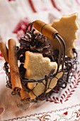 A wire basket of Christmas biscuits, pine cones and cinnamon sticks
